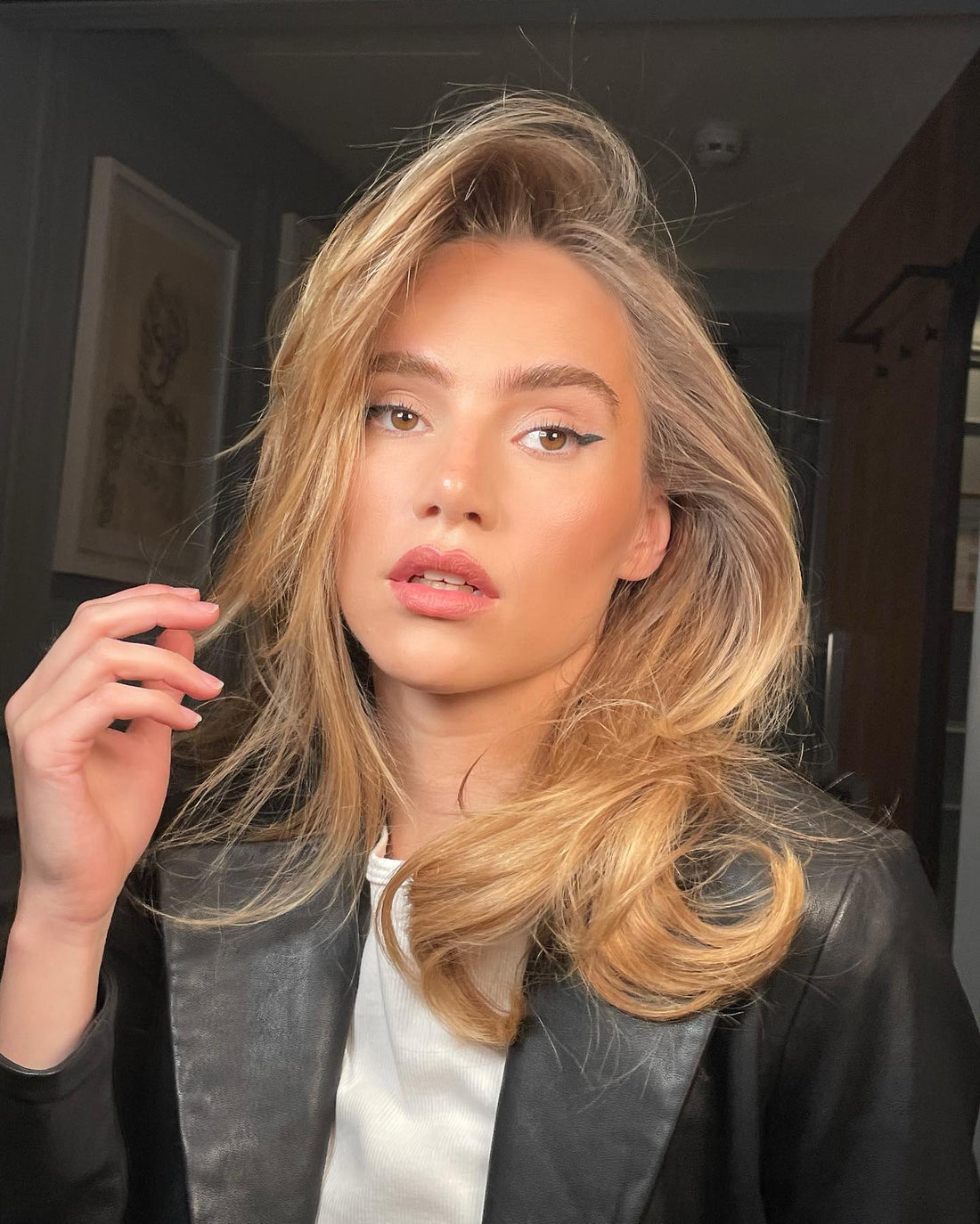 Woman with voluminous blonde hair, wearing leather jacket, showcases fresh dry shampoo look.