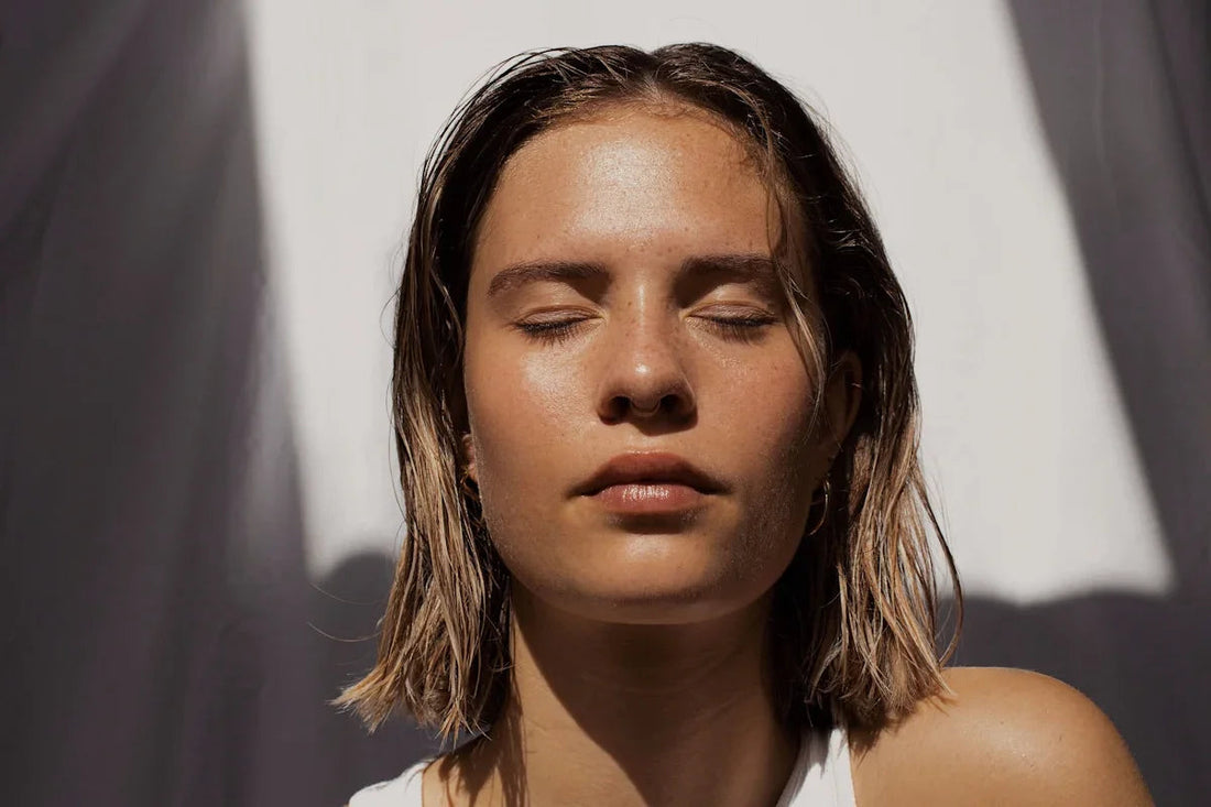 Woman with dewy, radiant skin and natural makeup in sunlight, luxury skincare concept