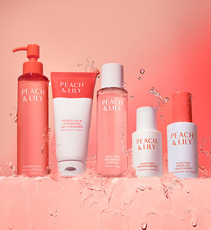 Peach & Lily skincare products on pink background with water splashes, beauty cleanser set