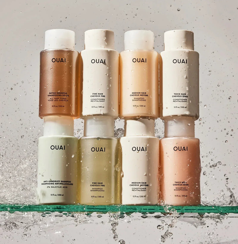 Luxurious OUAI shampoo and conditioner bottles in pastel hues with water splashes, Wylde Grey beauty