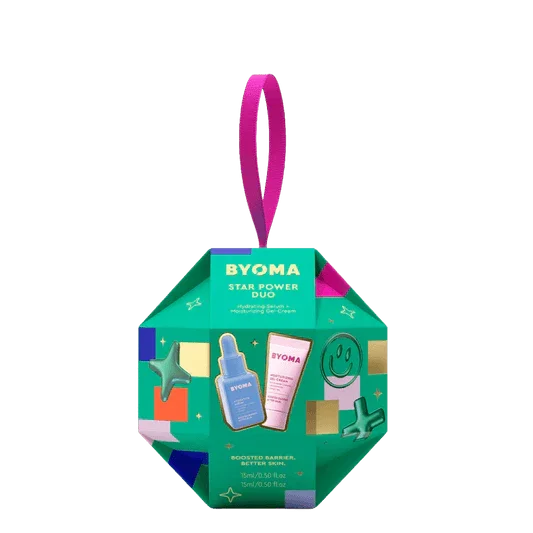 Luxurious green octagonal BYOMA skincare gift set with pink ribbon, featuring serum and cream.