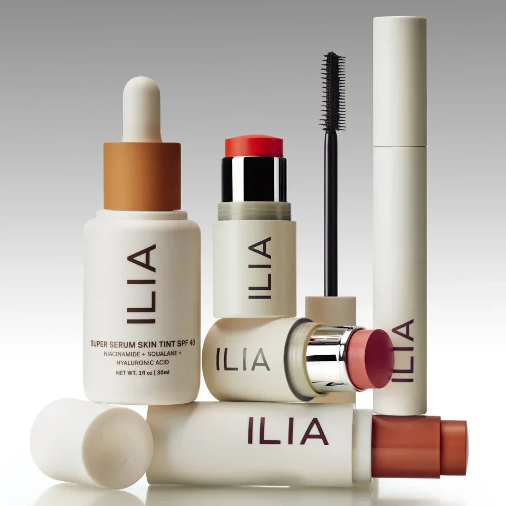 Luxury ILIA makeup collection with creamy blush, dewy serum skin tint, mascara and lipstick.