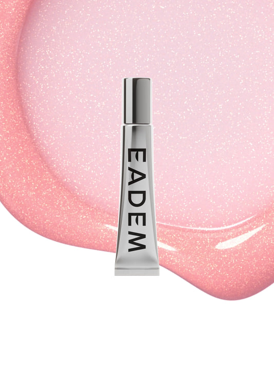 Silver tube of skincare over glossy, pink, shimmery cream texture, luxurious finish