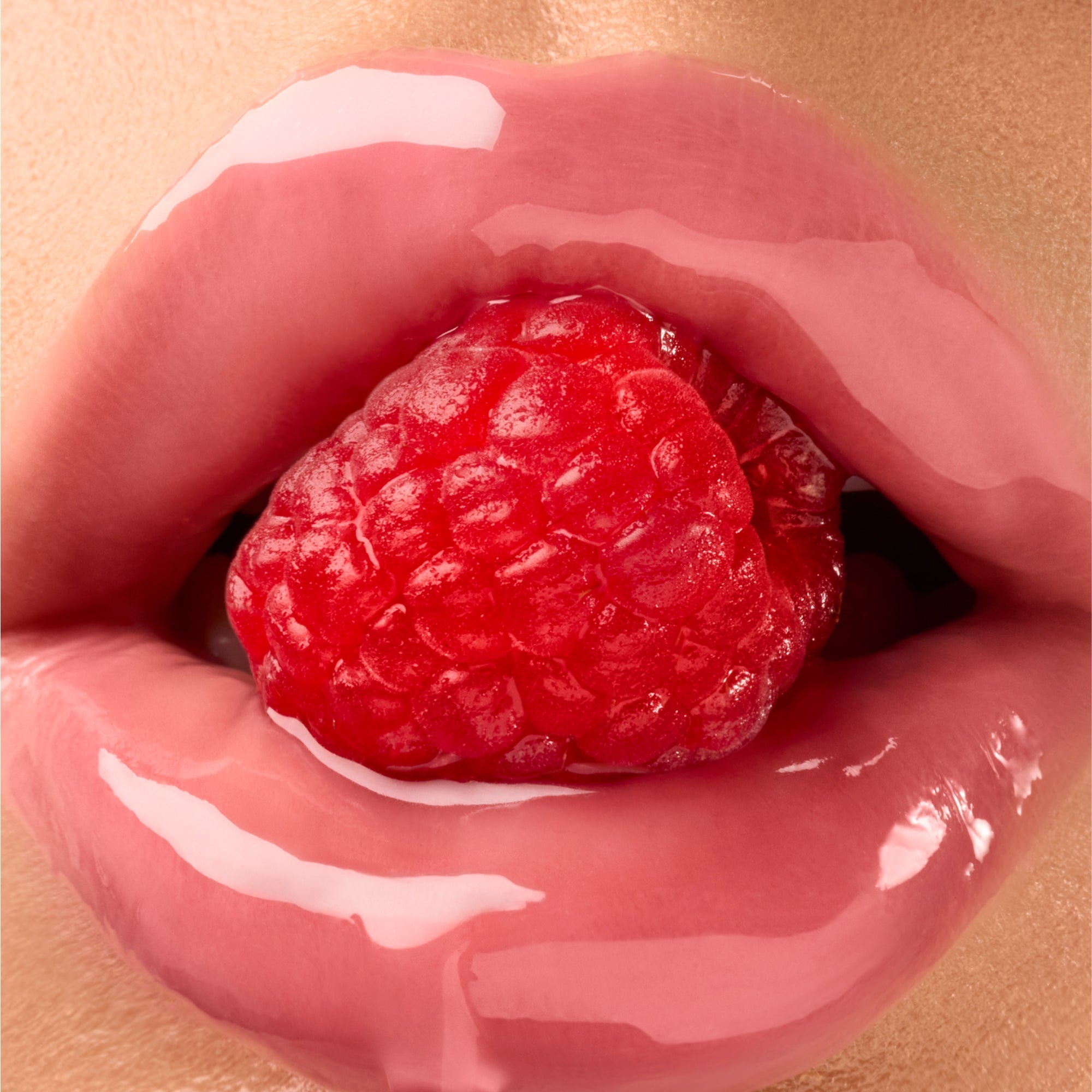 Glossy lips surrounding a raspberry.