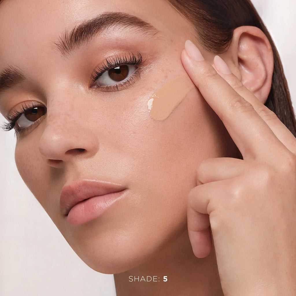 Model applying creamy beige liquid foundation, dewy finish, beauty skincare, Shade 5