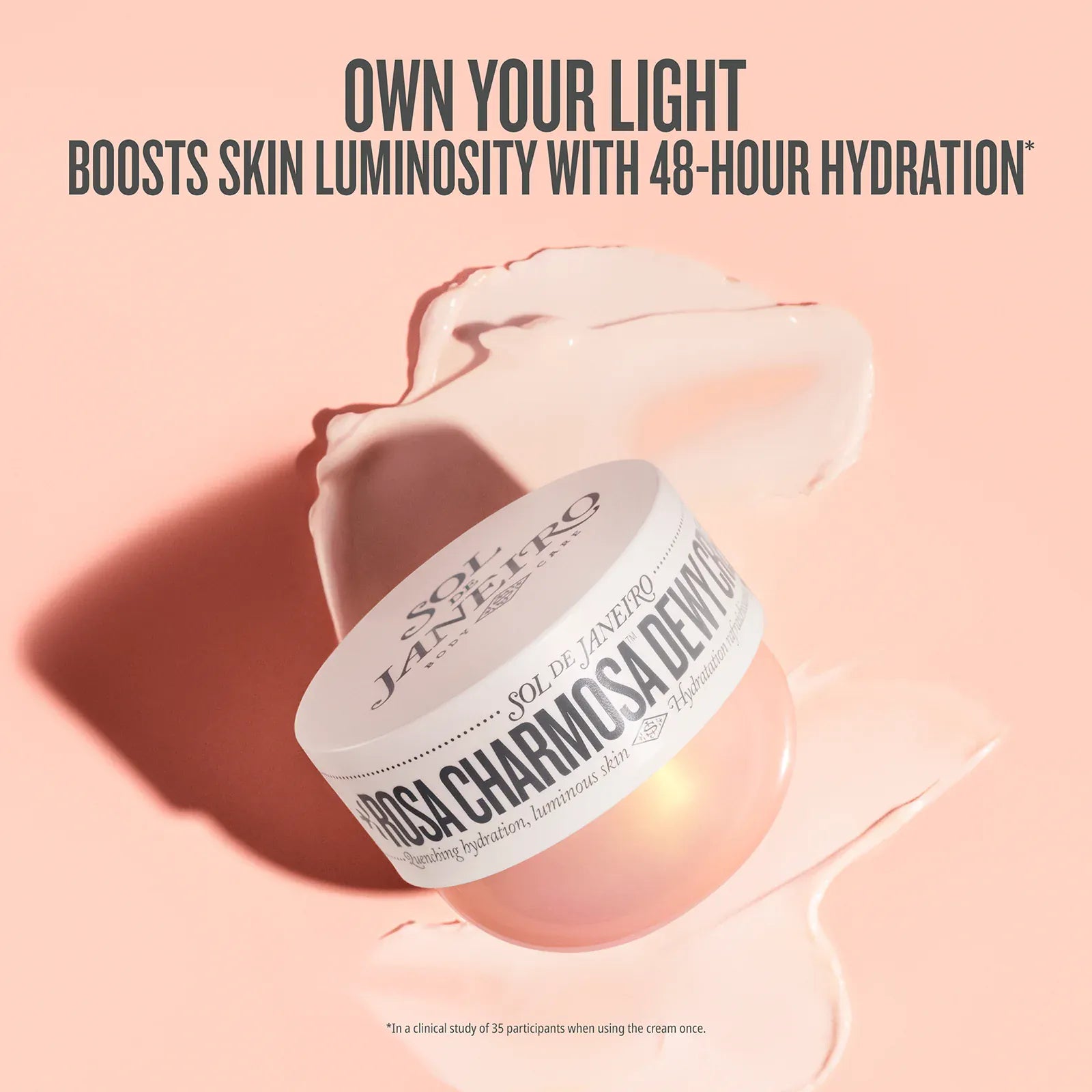 Cosmetic jar with cream on a pink background, featuring text about skin hydration. Text on image reads own your light boosts skin luminosity with 48-hour hydration*

*in a clinical study of 35 participants when using the cream once.