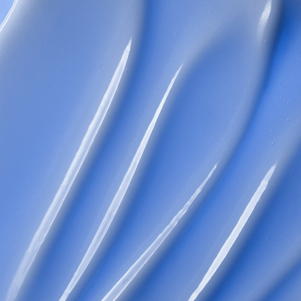  A glossy, light blue skincare cream with curved, textured swirls.
