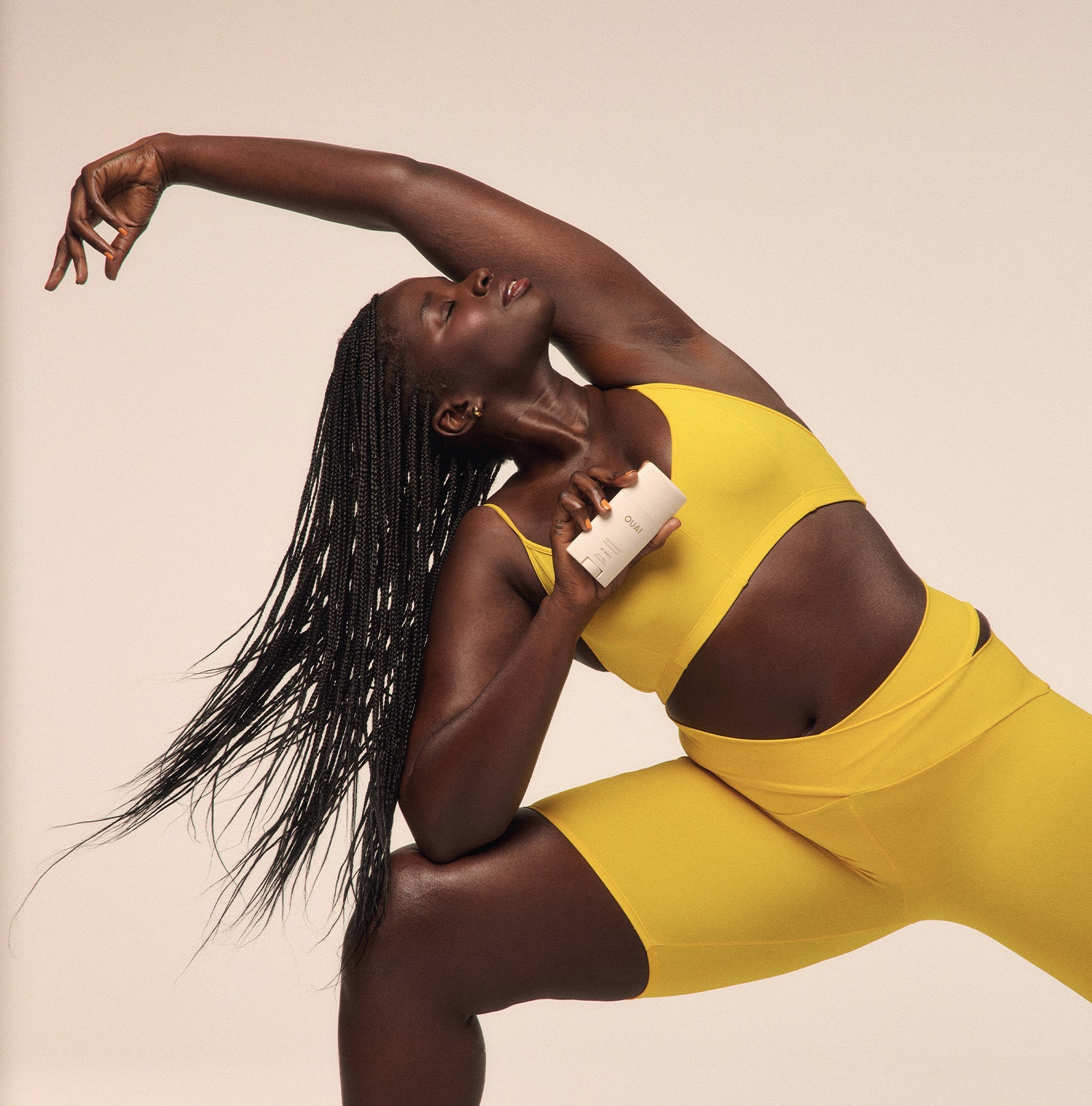 Woman in a yellow outfit posing against a beige background
