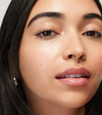 Close-up of woman with dewy glowing skin, defined brows, and glossy natural lips