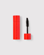 Luxurious red Westman Atelier mascara with glossy finish and black bristle wand on white background