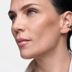 Close-up of woman with flawless, hydrated skin, natural makeup, and gold hoop earrings