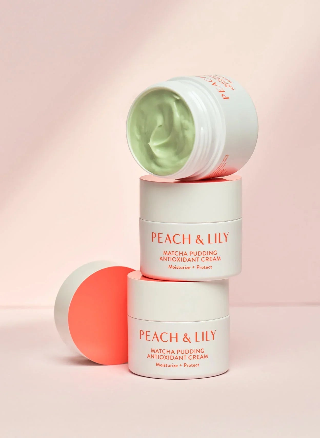 Peach & Lily Matcha Pudding Antioxidant Cream jars with creamy green texture, soft pink background