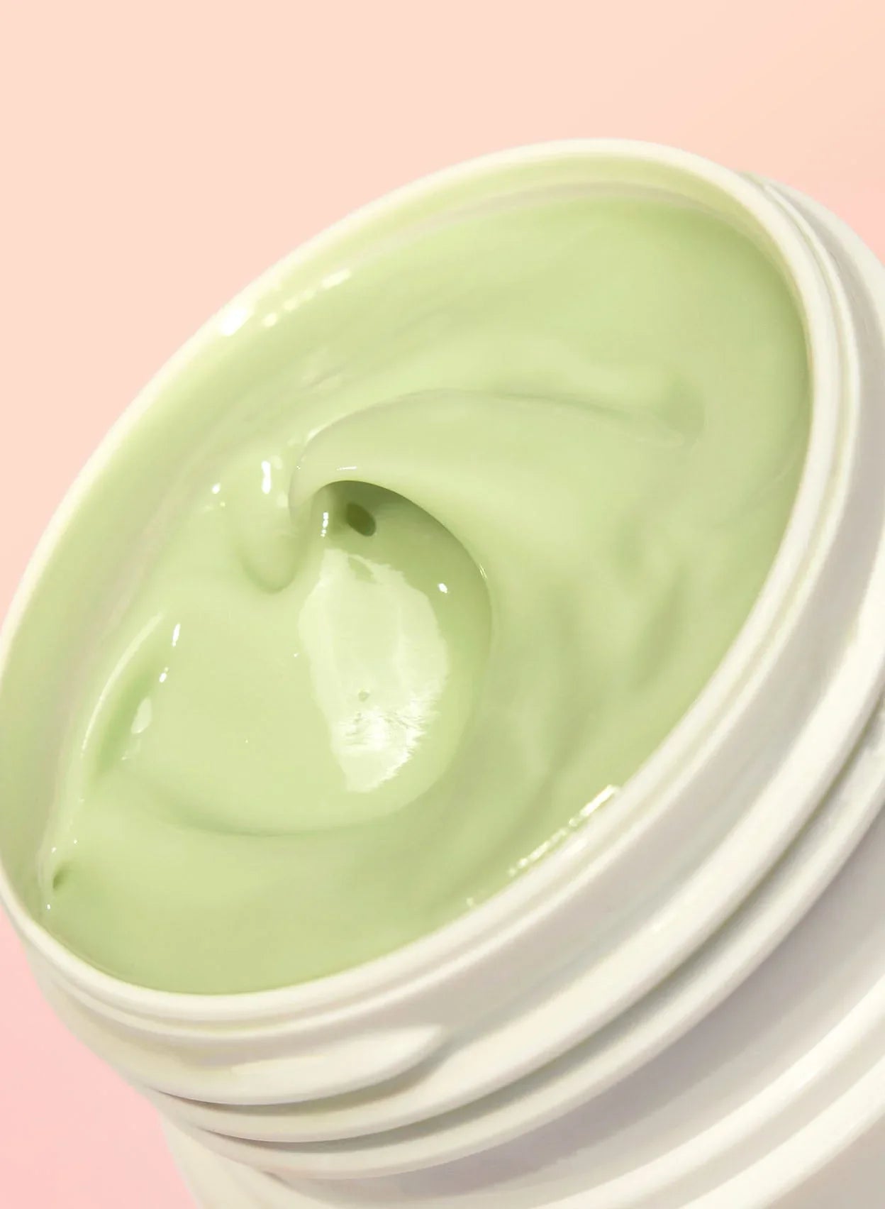 Luxurious light green creamy skincare mask in white jar on pink background, Wylde Grey