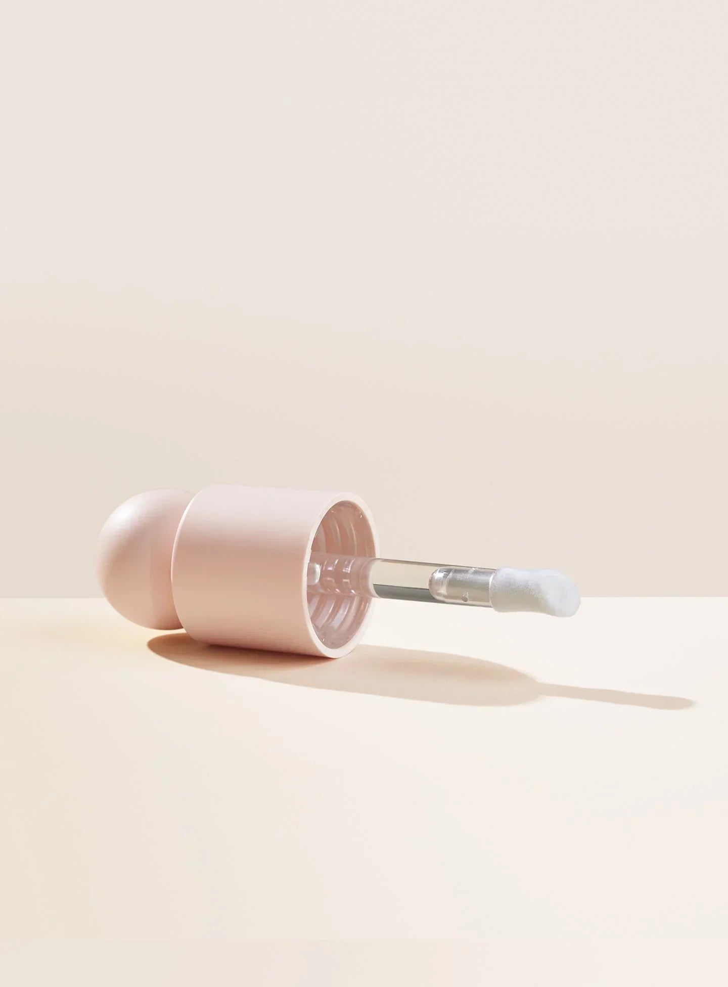 The applicator and cap for Rare Beauty's Positive Light Liquid Luminizer.