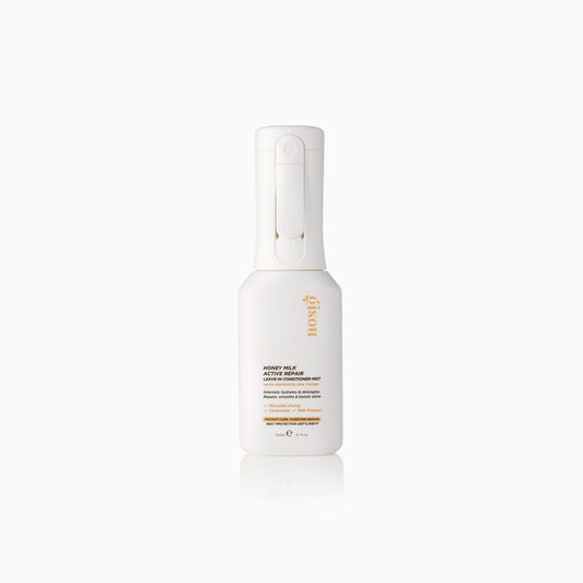 Sleek white leave-in conditioner bottle with gold accents and a smooth, matte texture.
