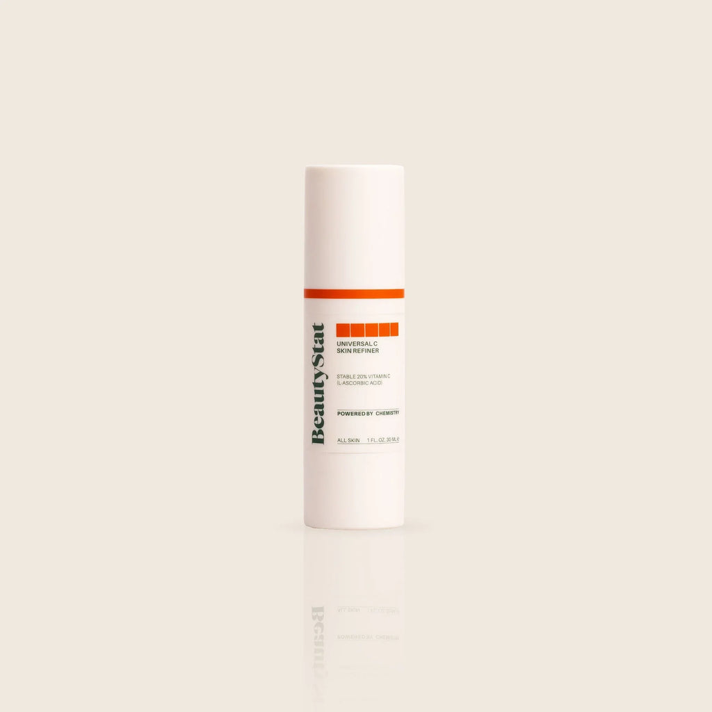 BeautyStat Universal C Skin Refiner serum in sleek white bottle with orange label, on beige background