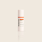 BeautyStat Universal C Skin Refiner serum in sleek white bottle with orange label, on beige background