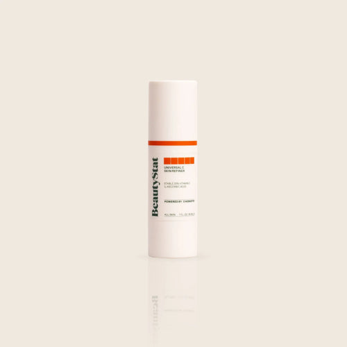 BeautyStat Universal C Skin Refiner serum in sleek white bottle with orange label, on beige background