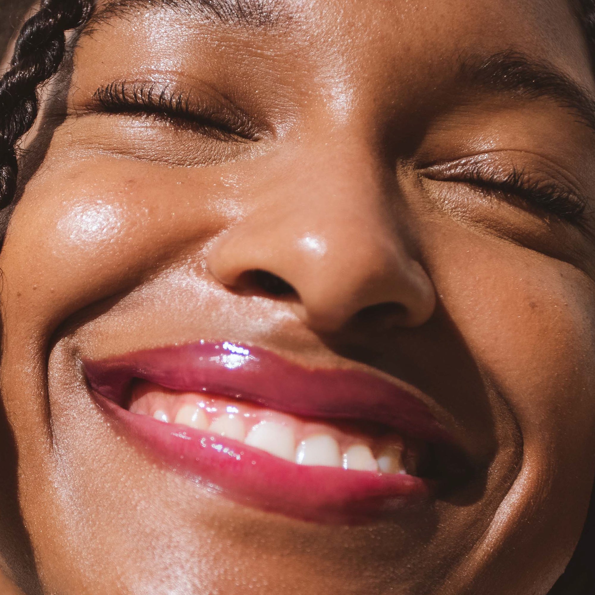 A model wearing the Tower 28 Beauty ShineOn Lip Jelly in the shade Wild on her lips. [Wild]