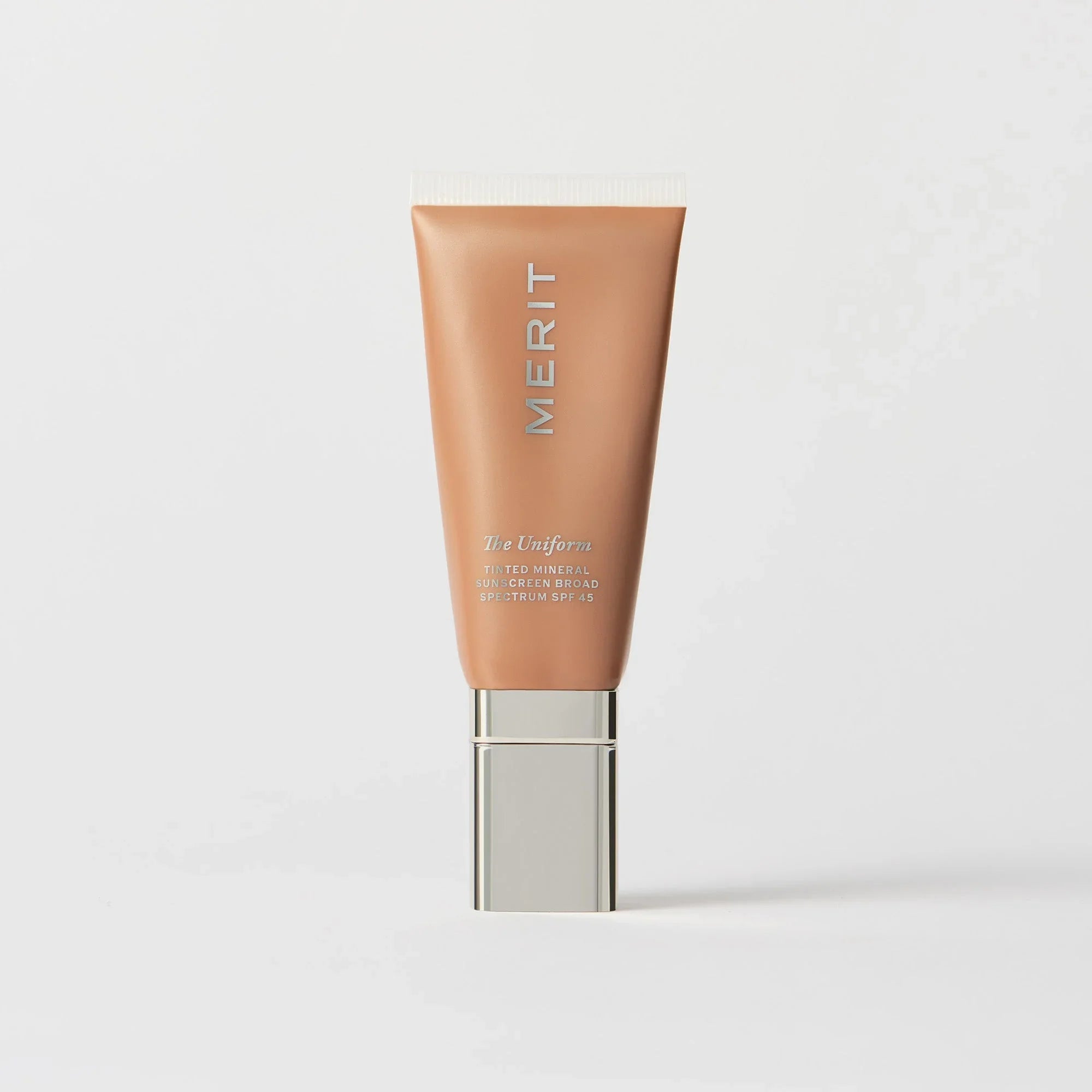 Master || A tube of MERIT brand mineral sunscreen with a sheer tint finish, providing broad spectrum 45 UVA/UVB protection, displayed against a white background. Shade 16
