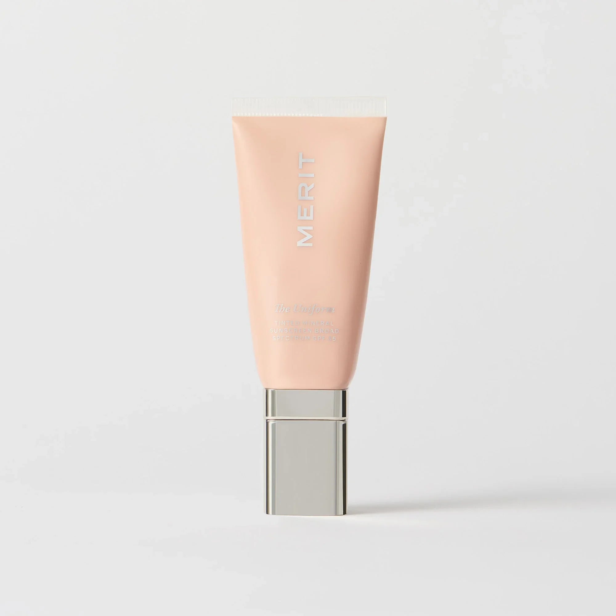 Master || A tube of MERIT brand mineral sunscreen with a sheer tint finish, providing broad spectrum 45 UVA/UVB protection, displayed against a white background. Shade 30