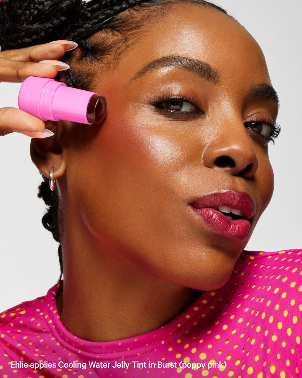 Woman applying pink Cooling Water Jelly Tint blush to cheek, wearing dotted pink top