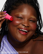 Woman smiling and applying red Cooling Water Jelly Tint in Chill to her cheek
