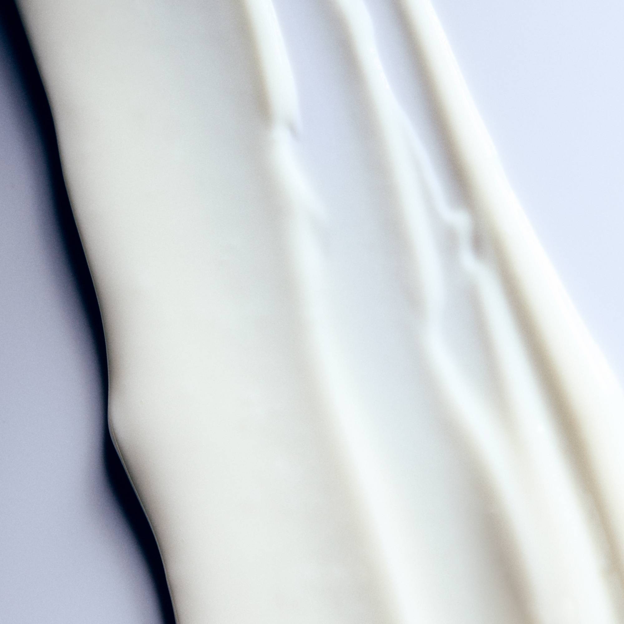 Close-up of white goop with soft folds on a light gray background