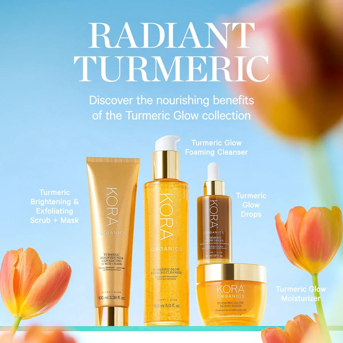 Kora Organics Turmeric Glow skincare set with orange and gold packaging against a blue background, surrounded by fresh tulips.