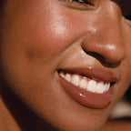 A model wearing the Tower 28 Beauty ShineOn Lip Jelly in the shade Almond on her lips. [Almond]