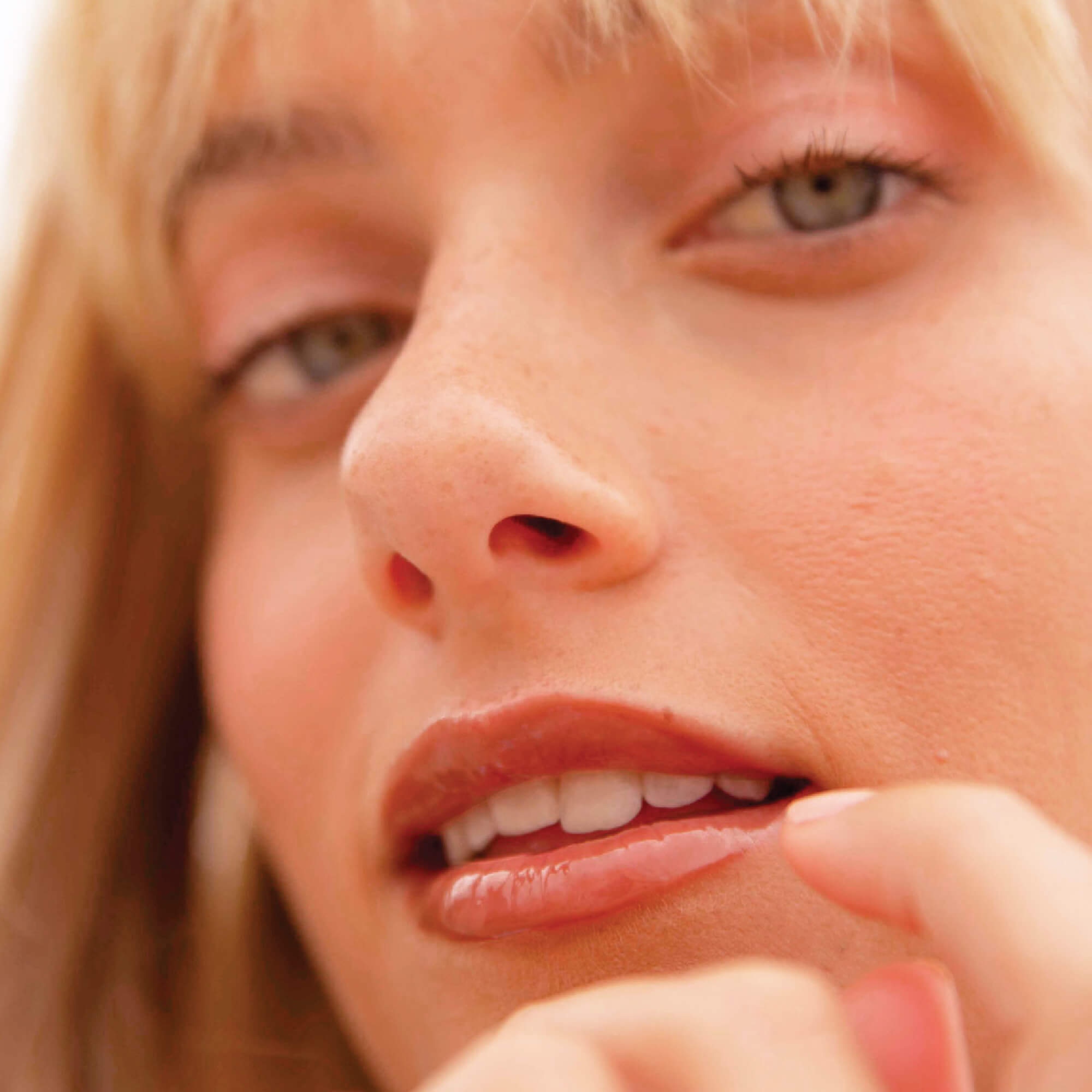 A model wearing the Tower 28 Beauty ShineOn Lip Jelly in the shade Cashew on her lips. [Cashew]