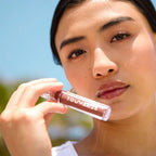 A model wearing the Tower 28 Beauty ShineOn Lip Jelly in the shade Almond on her lips. [Almond]