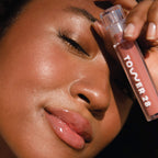 A model wearing the Tower 28 Beauty ShineOn Lip Jelly in the shade Cashew on her lips. [Cashew]