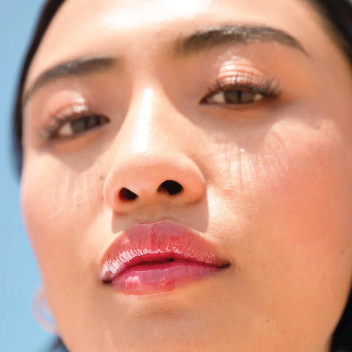 A model wearing the Tower 28 Beauty ShineOn Lip Jelly in the shade Coconut on her lips. [Coconut]