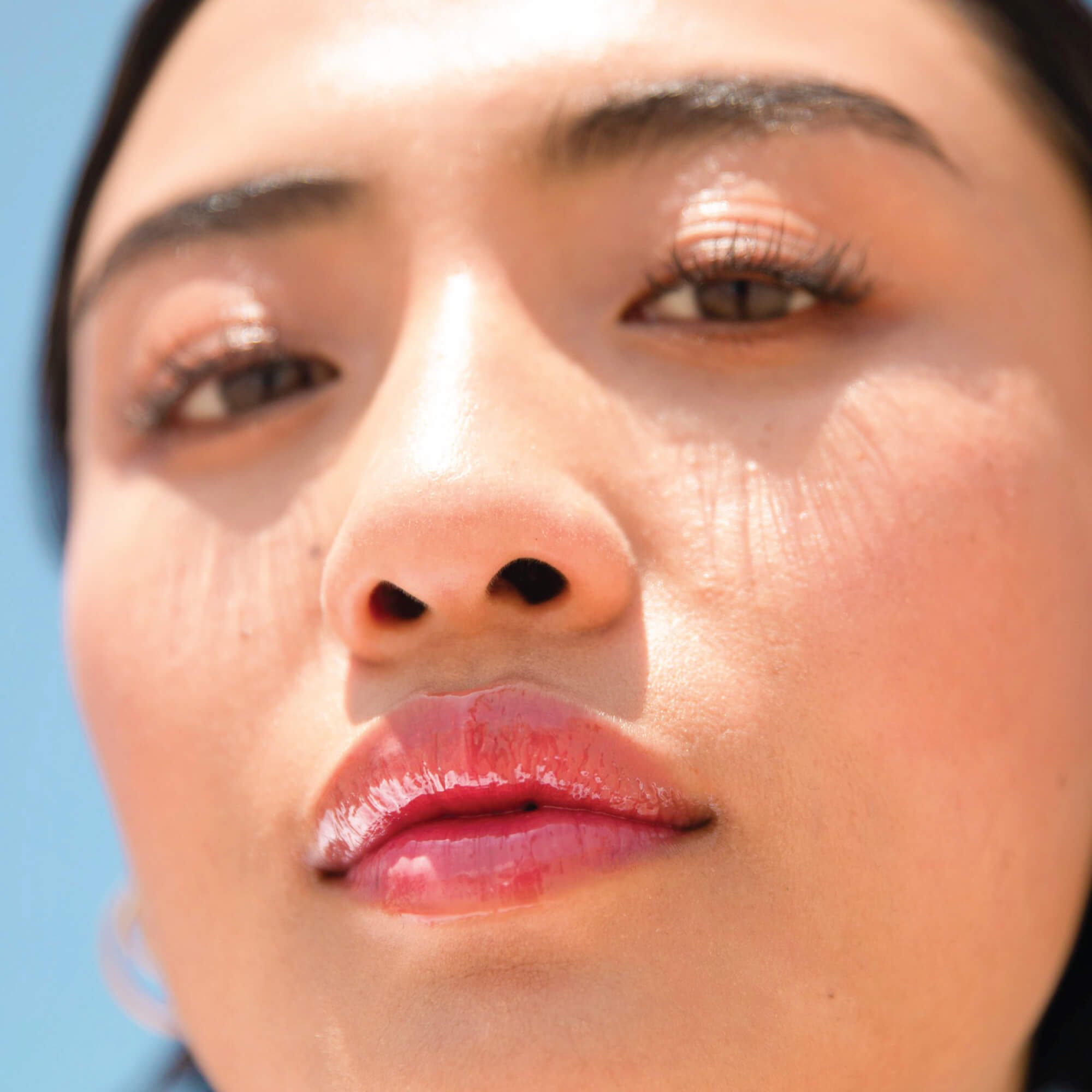 A model wearing the Tower 28 Beauty ShineOn Lip Jelly in the shade Coconut on her lips. [Coconut]