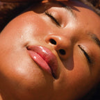 A model wearing the Tower 28 Beauty ShineOn Lip Jelly in the shade Coconut on her lips. [Coconut]