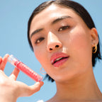 A model wearing the Tower 28 Beauty ShineOn Lip Jelly in the shade Coconut on her lips. [Coconut]