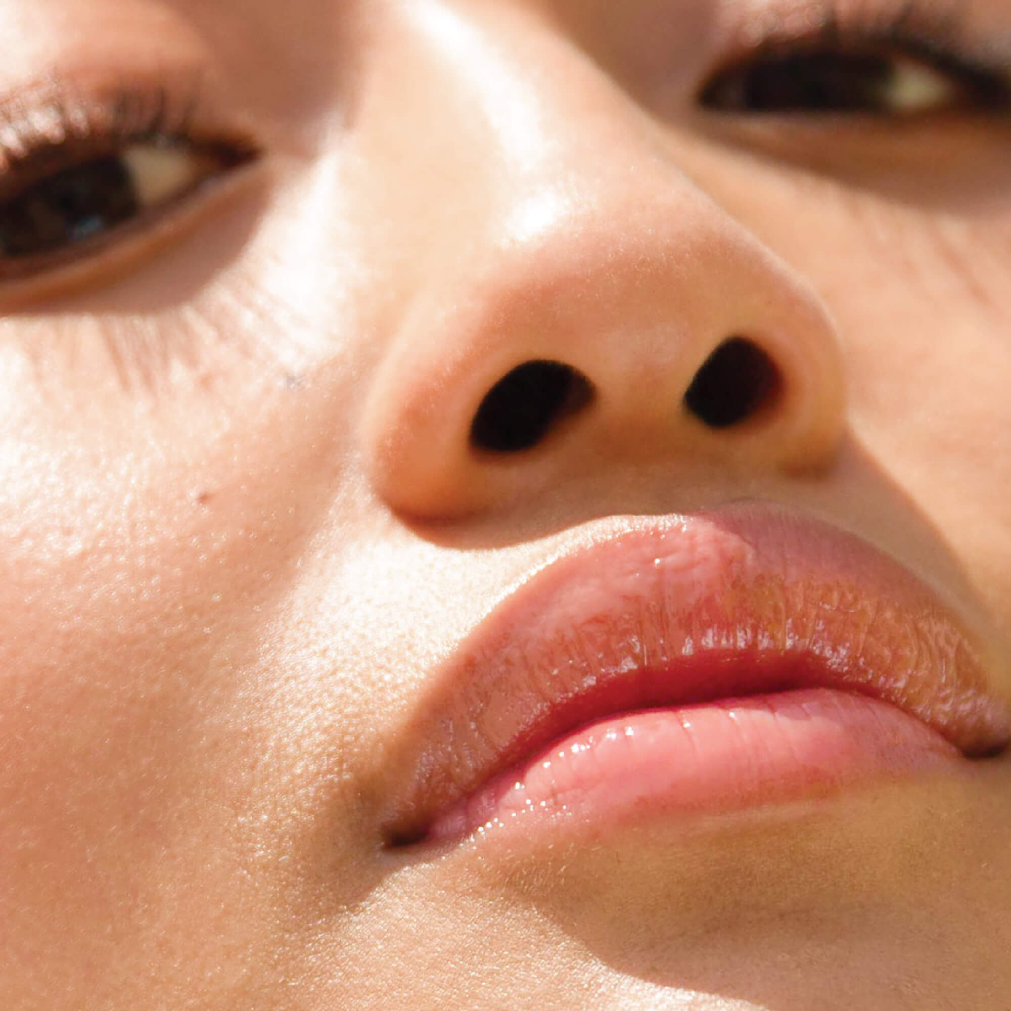 A model wearing the Tower 28 Beauty ShineOn Lip Jelly in the shade Oat on her lips. [Oat]
