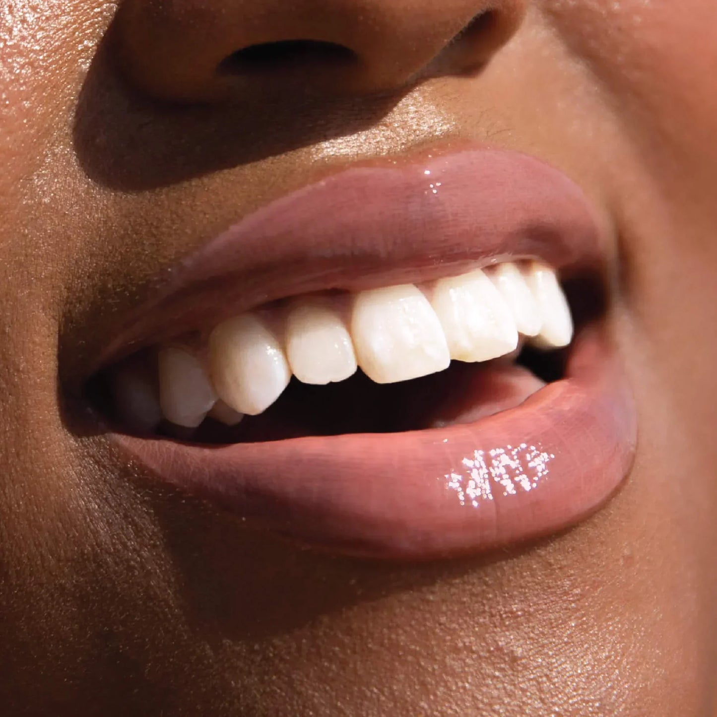 A model wearing the Tower 28 Beauty ShineOn Lip Jelly in the shade Oat on her lips. [Oat]