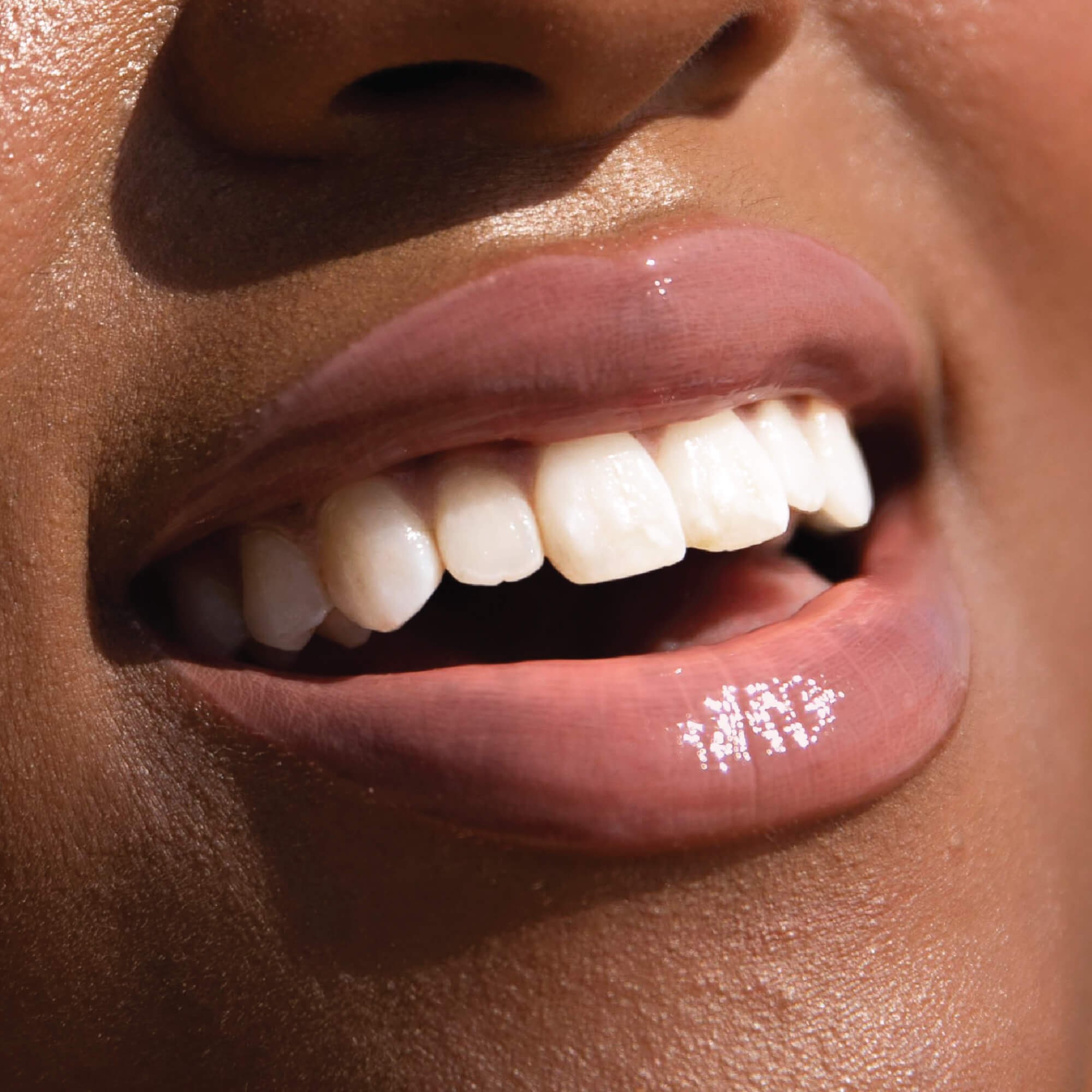 A model wearing the Tower 28 Beauty ShineOn Lip Jelly in the shade Oat on her lips. [Oat]