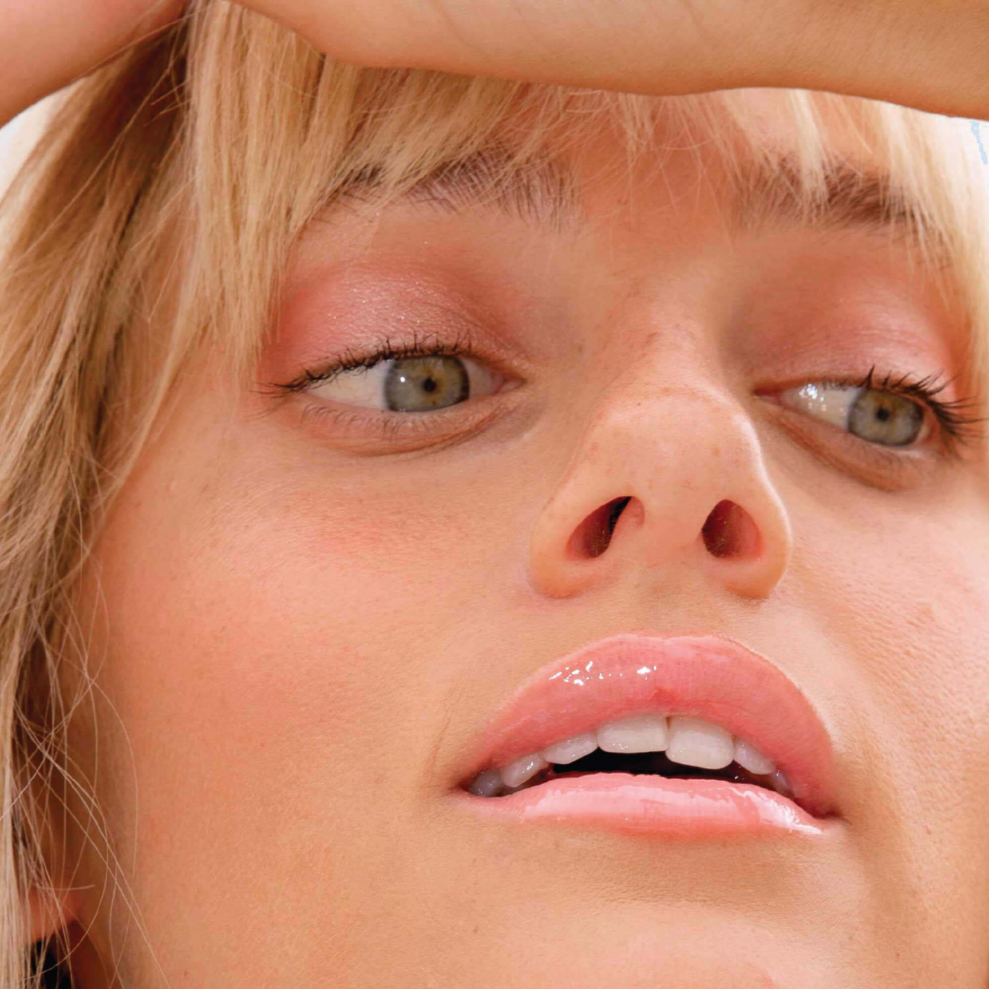 A model wearing the Tower 28 Beauty ShineOn Lip Jelly in the shade Oat on her lips. [Oat]