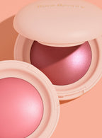 | A close-up shot of two shades of Rare Beauty's Soft Pinch Luminous Powder Blush laying open against a pink background.