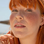 A model wearing the Tower 28 Beauty ShineOn Lip Jelly in the shade Chill on her lips. [Chill]