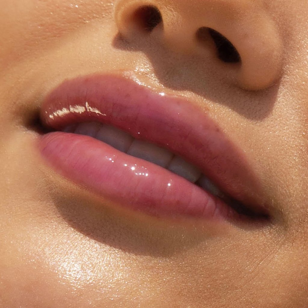 A model wearing the Tower 28 Beauty ShineOn Lip Jelly in the shade Fear Less on her lips. [Fear Less]