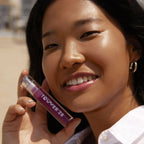 A model wearing the Tower 28 Beauty ShineOn Lip Jelly in the shade Fear Less on her lips. [Fear Less]