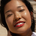 A model wearing the Tower 28 Beauty ShineOn Lip Jelly in the shade Spicy on her lips. [Spicy]