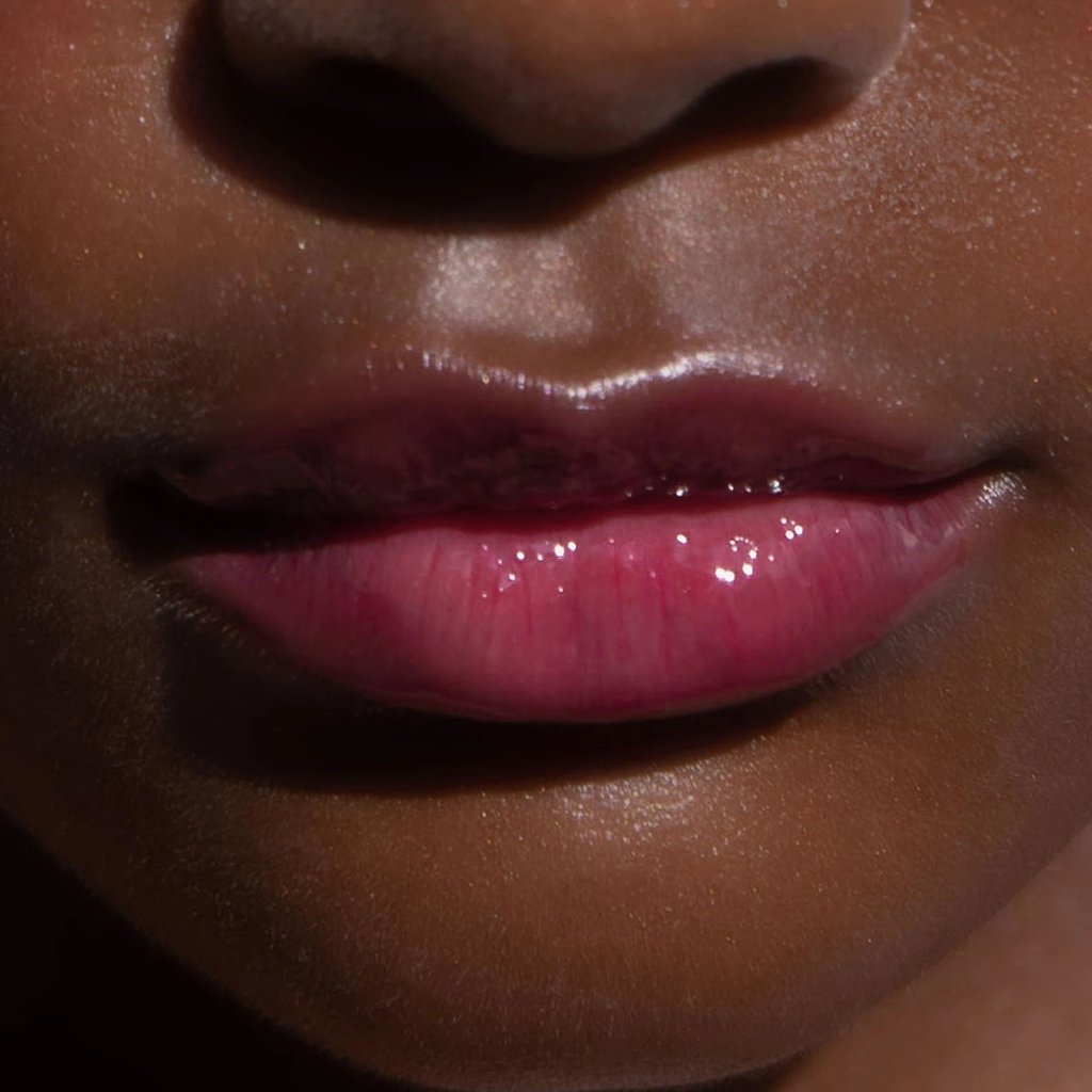 A model wearing the Tower 28 Beauty ShineOn Lip Jelly in the shade XOXO on her lips. [XOXO]