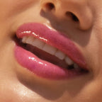 A model wearing the Tower 28 Beauty ShineOn Lip Jelly in the shade XOXO on her lips. [XOXO]