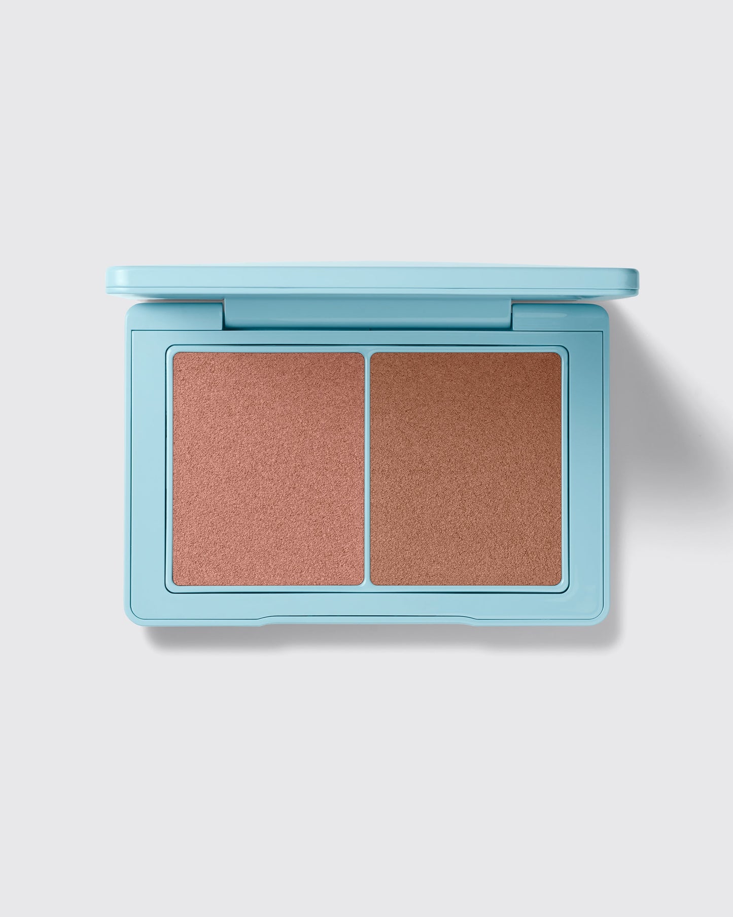 Makeup compact with two brown shades on a light gray background