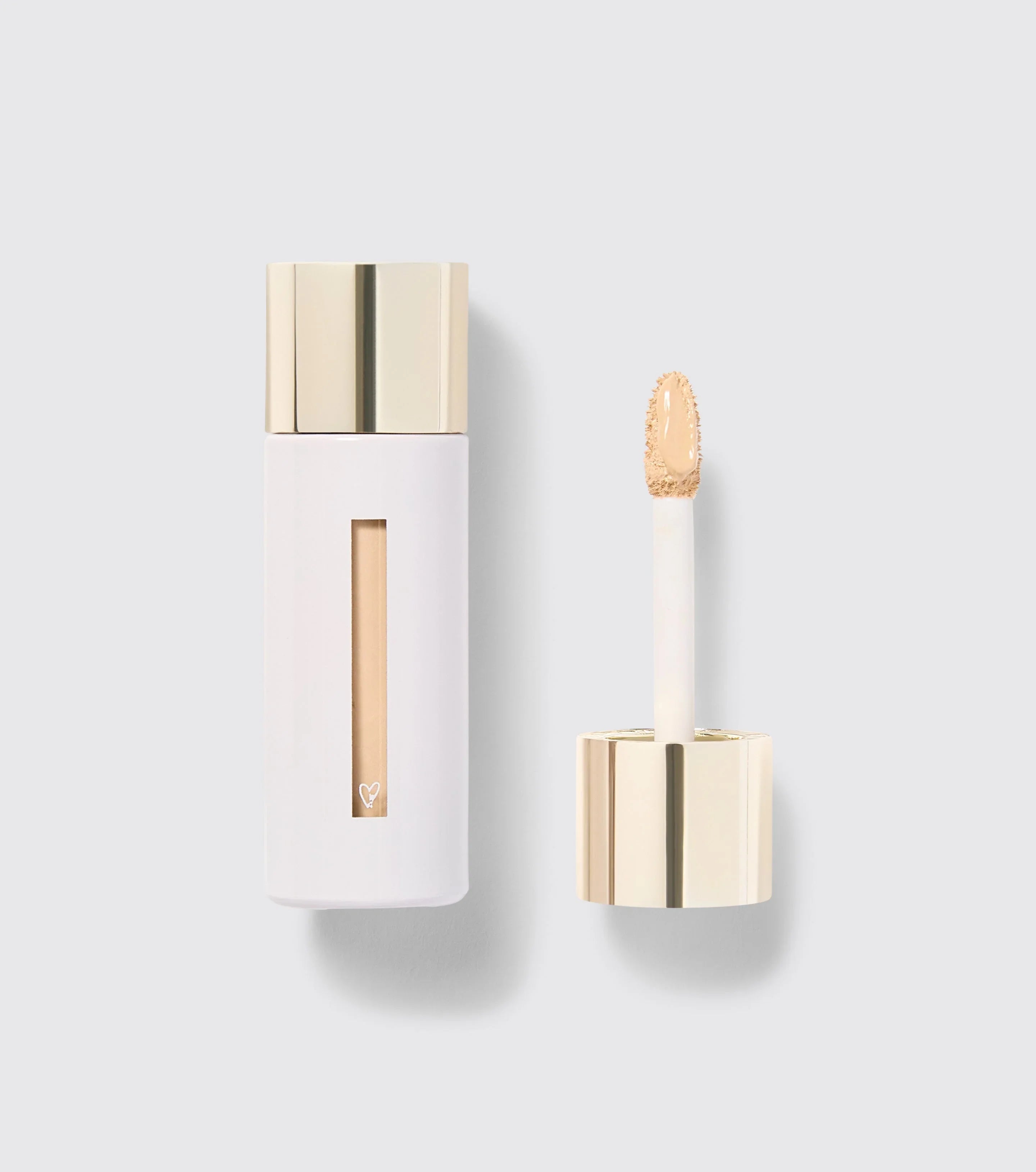 Luxury concealer with creamy beige texture in sleek white and gold packaging on display